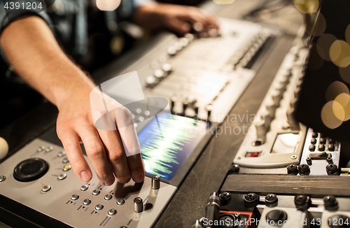 Image of man using mixing console in music recording studio