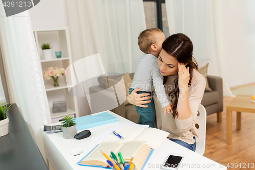 Image of mother student with baby learning at home