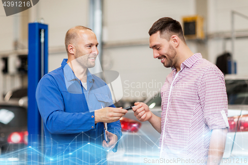 Image of auto mechanic giving key to man at car shop