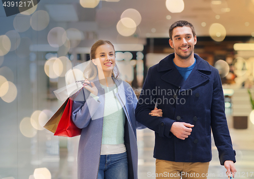 Image of happy young couple with shopping bags in mall