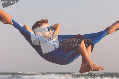 Image of Happy little boy relaxing on the beach at the day time