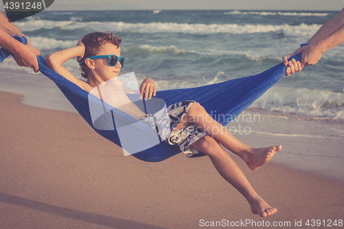 Image of Happy little boy relaxing on the beach at the day time