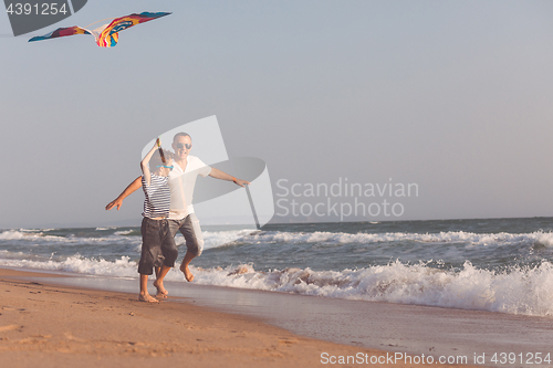 Image of Father and son playing on the beach at the day time.