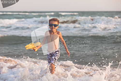 Image of One happy little boy playing on the beach at the day time.