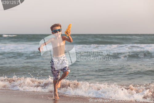 Image of One happy little boy playing on the beach at the day time.