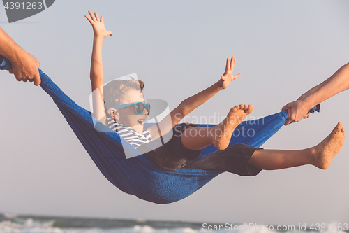 Image of Happy little boy relaxing on the beach at the day time