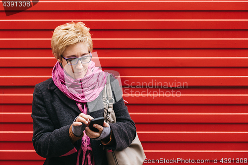 Image of Adult woman with smartphone on street