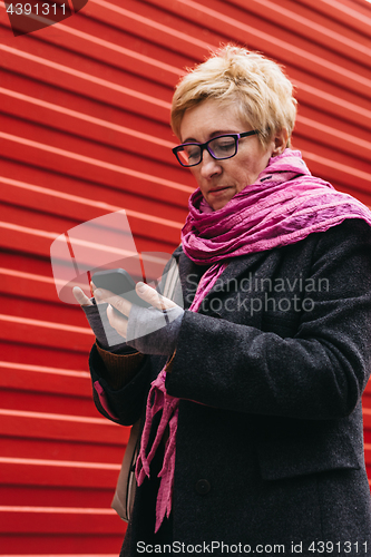 Image of Woman with smartphone in city