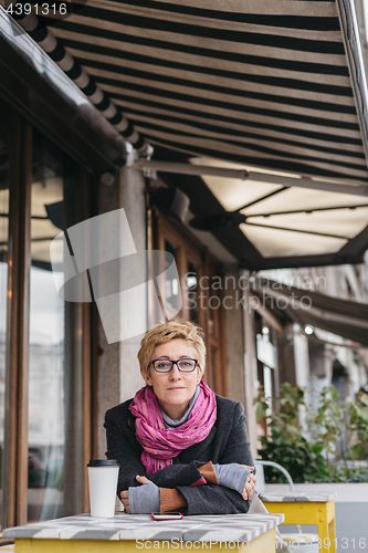 Image of Dreamy woman with phone in cafe