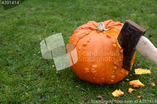 Image of Axe hacking into a large orange pumpkin