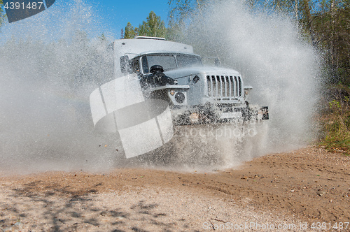 Image of truck passes through a puddle