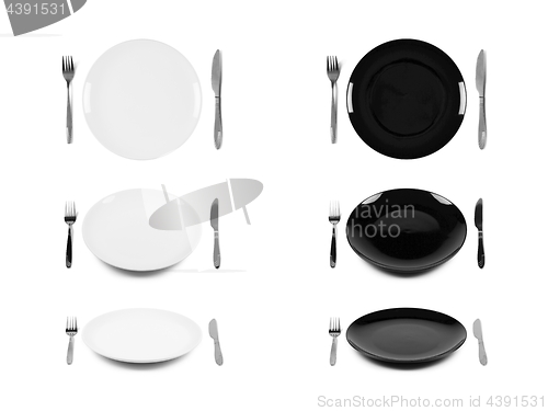 Image of Two sets of white and black plates with fork and knife