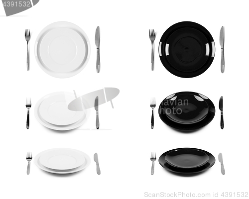 Image of Two sets of white and black plates with fork and knife