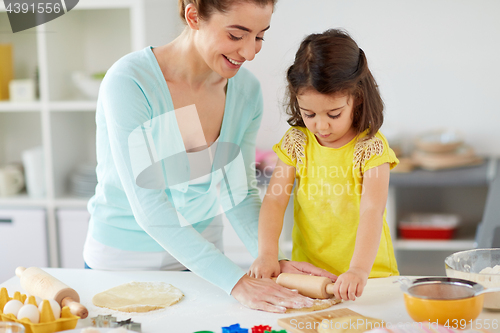 Image of happy mother and daughter making cookies at home