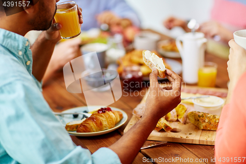 Image of close up of man drinking orange juice with toast