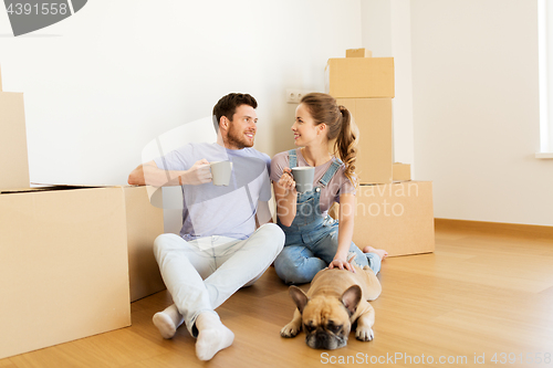 Image of happy couple with boxes and dog moving to new home