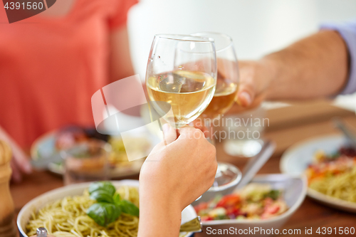 Image of hands clinking wine glasses