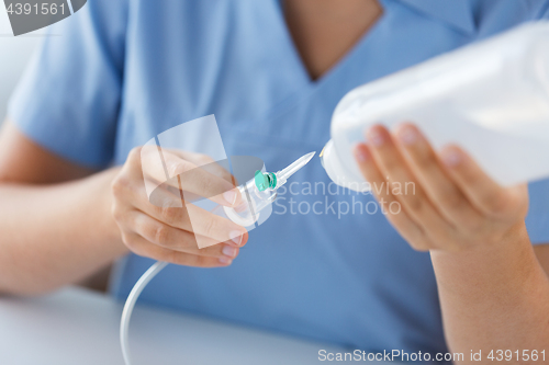 Image of close up of nurse preparing drop counter