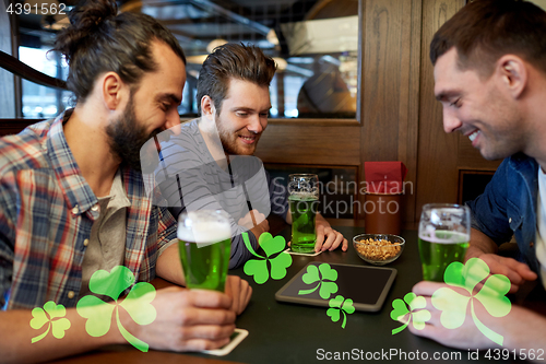 Image of friends with tablet pc and green beer at pub