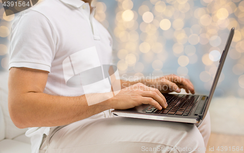 Image of close up of man typing on laptop keyboard