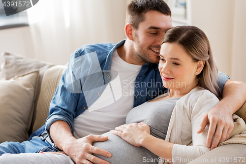 Image of man hugging pregnant woman at home