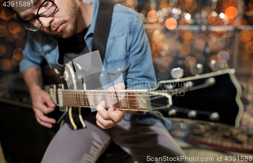 Image of musician playing guitar at studio or music concert