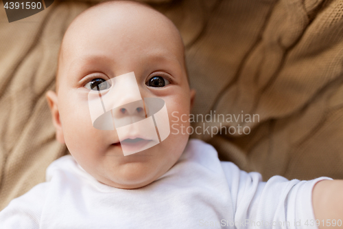 Image of close up of sweet little baby boy lying on blanket