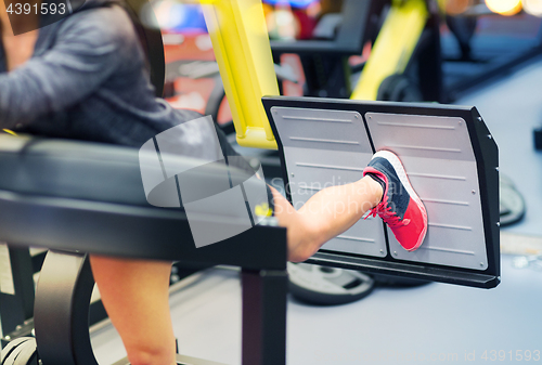 Image of woman flexing muscles on leg press machine in gym