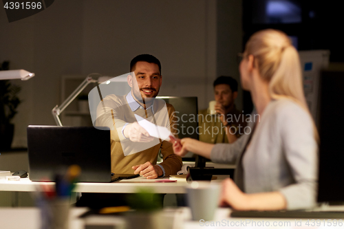 Image of coworkers with papers working late at office