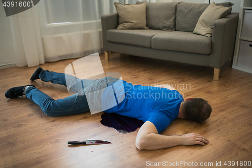 Image of dead man body lying on floor at crime scene