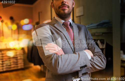 Image of close up of man in suit and tie at clothing store