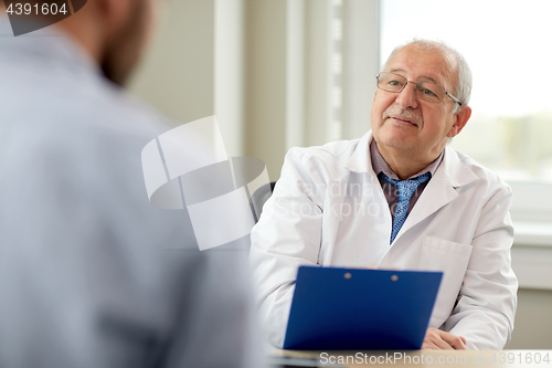 Image of senior doctor talking to male patient at hospital