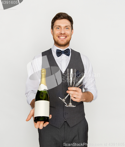 Image of man with bottle of champagne and glasses at party