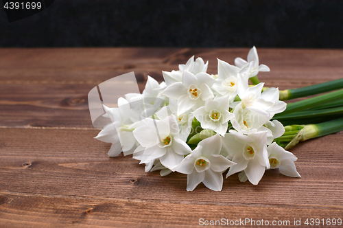 Image of Freshly cut bunch of white narcissi on a wooden table