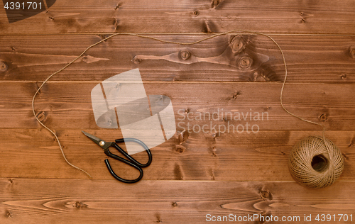 Image of Ball of twine unwound across a wooden background