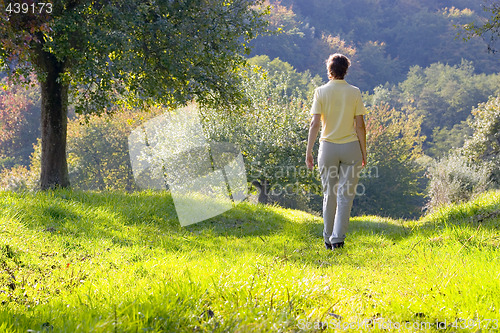 Image of Woman walking in a autumn landscape