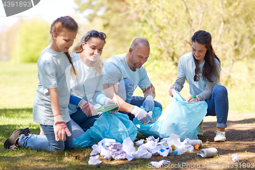 Image of volunteers with garbage bags cleaning park area