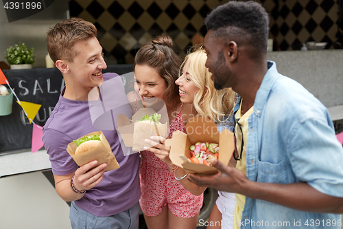 Image of happy friends with wok and burger at food truck