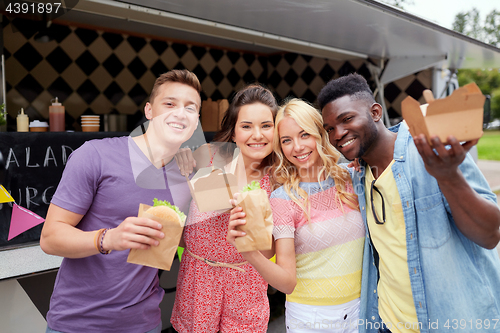 Image of happy friends with wok and burger at food truck