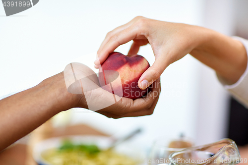 Image of multiracial couple hands with peach