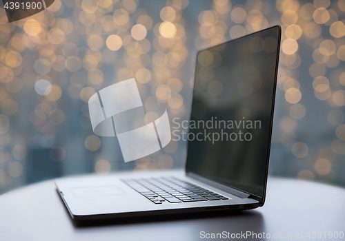 Image of laptop and coffee cup on table at christmas