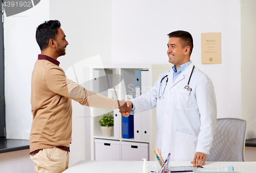 Image of doctor and male patient shaking hands at hospital