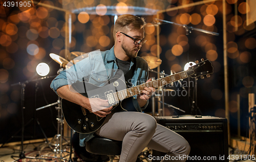 Image of man playing guitar at studio rehearsal