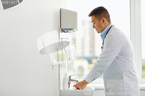 Image of doctor washing hands at medical clinic sink