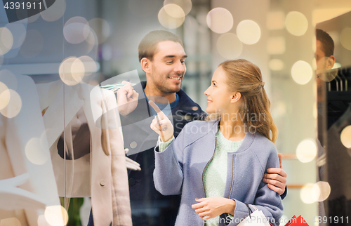 Image of happy young couple with shopping bags in mall