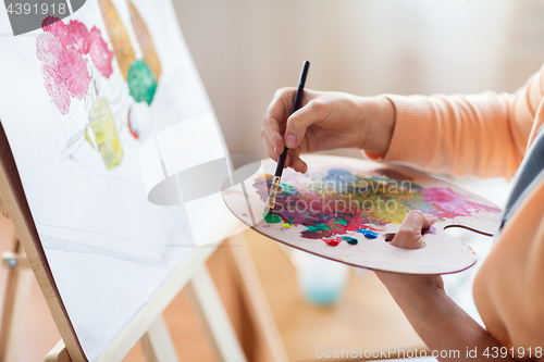 Image of artist with palette painting at art studio