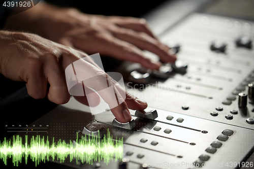 Image of hands on mixing console at sound recording studio