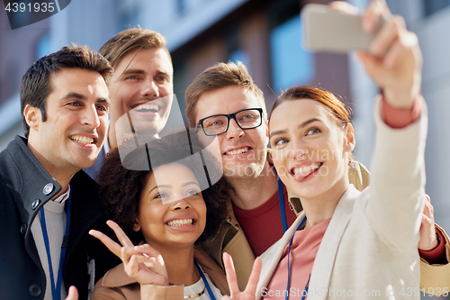 Image of business team with conference badges taking selfie