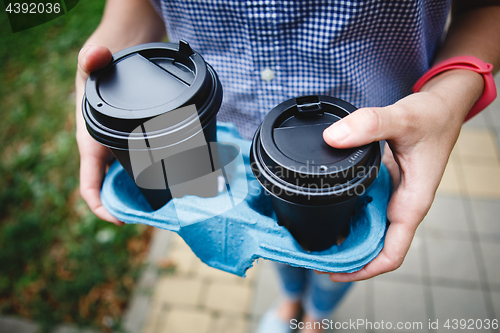 Image of Crop person holding coffee cups