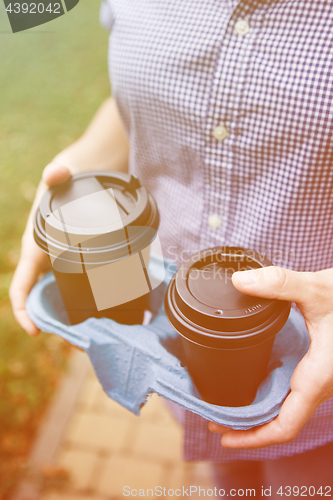 Image of Crop person holding coffee cups